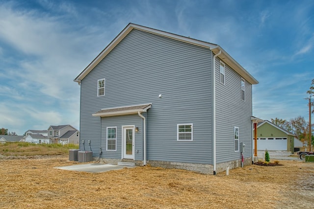 rear view of house featuring a lawn, cooling unit, and a patio