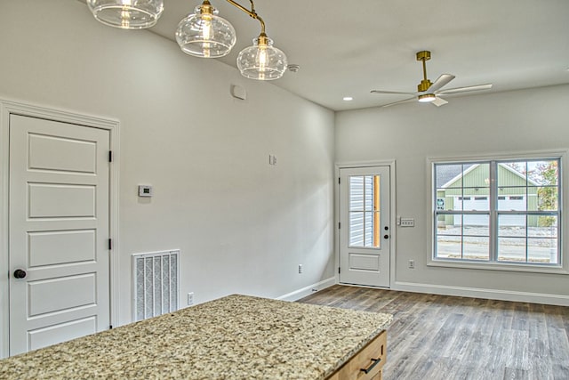 interior space with ceiling fan, wood finished floors, visible vents, and baseboards