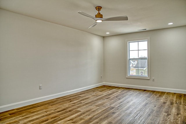 empty room featuring visible vents, ceiling fan, baseboards, and wood finished floors