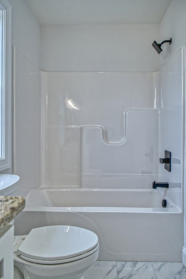 bathroom featuring marble finish floor, vanity, toilet, and bathtub / shower combination