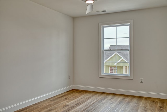 unfurnished room featuring light wood-type flooring, visible vents, and baseboards