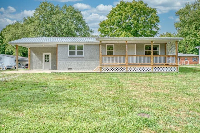 rear view of house with a lawn, metal roof, an attached carport, crawl space, and brick siding