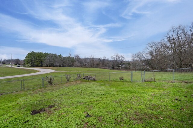 view of yard featuring fence and a rural view