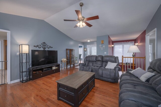 living room featuring vaulted ceiling, wood finished floors, and baseboards