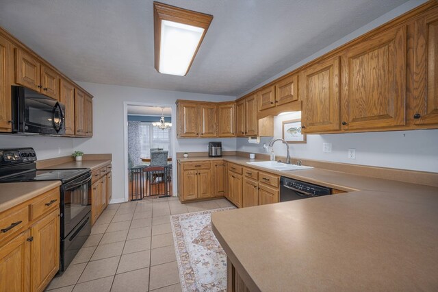 kitchen featuring black appliances, a sink, light countertops, and brown cabinets