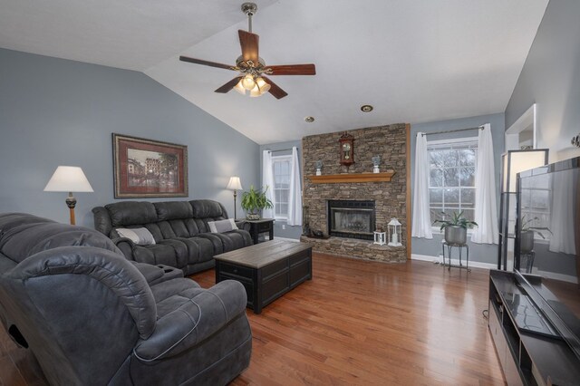 living area with a fireplace, dark wood-type flooring, vaulted ceiling, ceiling fan, and baseboards