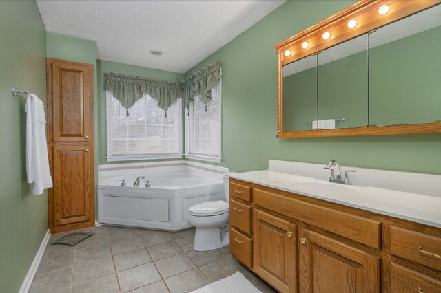 full bath featuring a textured ceiling, toilet, vanity, a bath, and tile patterned floors