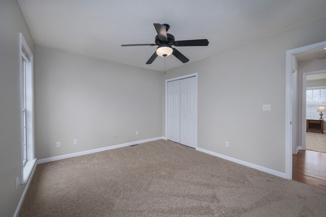 unfurnished bedroom featuring a closet, light colored carpet, and baseboards