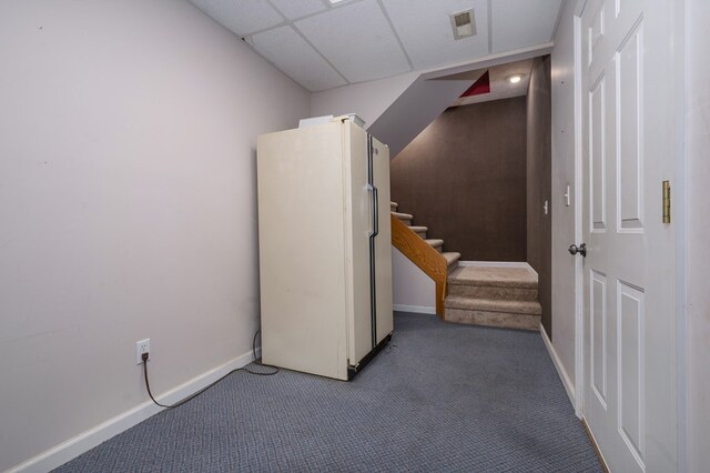 interior space with baseboards, carpet flooring, stairway, and a drop ceiling