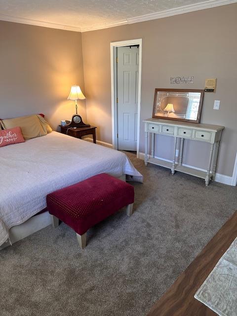 bedroom with light carpet, baseboards, and a textured ceiling