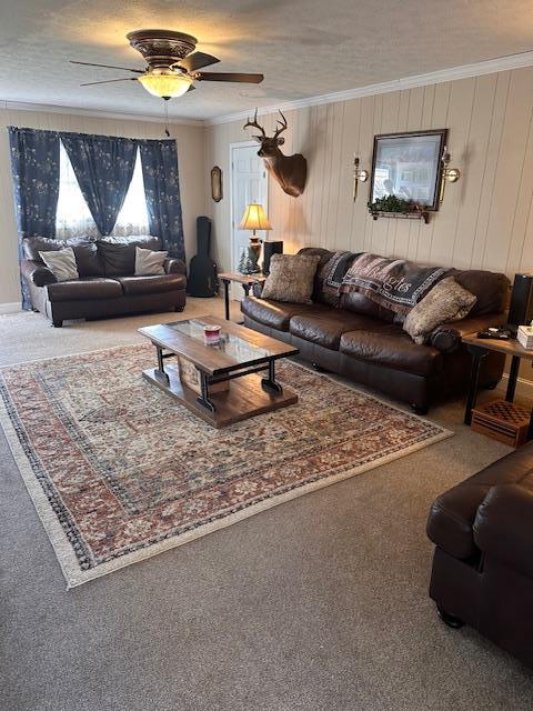 carpeted living area with a ceiling fan