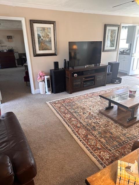 carpeted living room featuring ceiling fan and baseboards