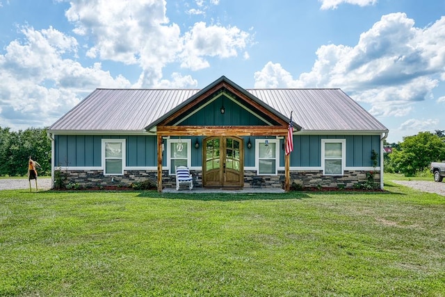 view of front of property with stone siding, metal roof, and board and batten siding