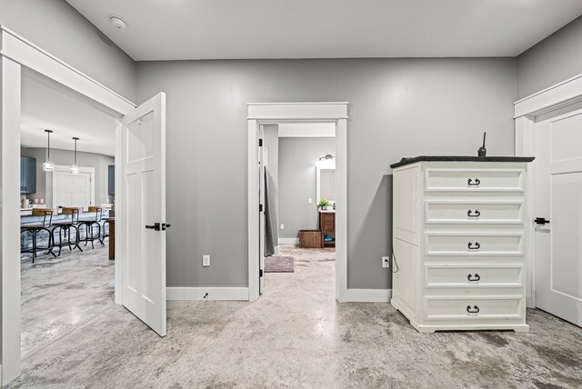 interior space with concrete floors and baseboards