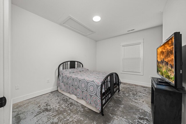 bedroom with attic access, concrete floors, visible vents, and baseboards