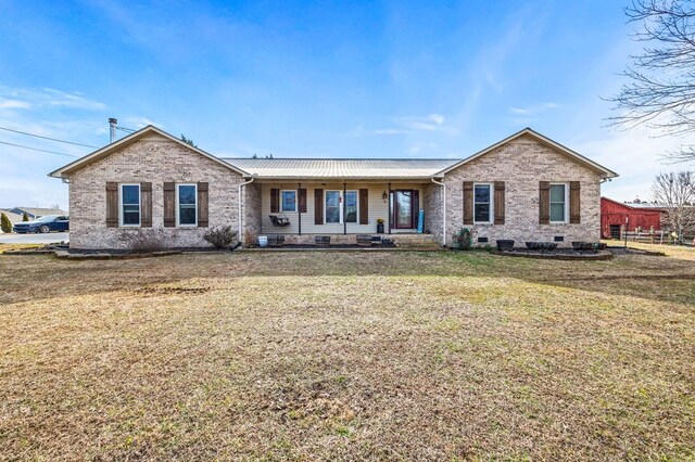 ranch-style home with metal roof, covered porch, brick siding, crawl space, and a front yard