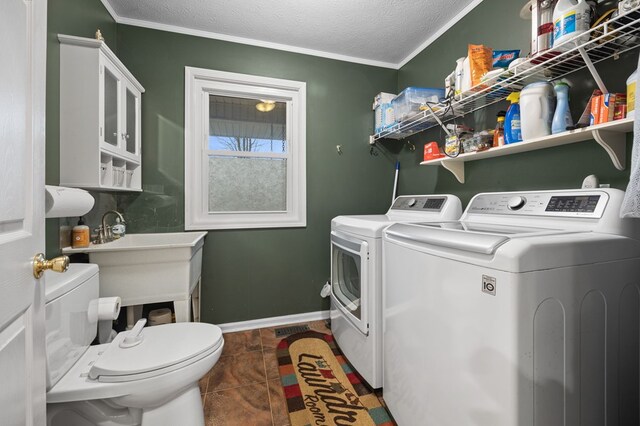 laundry room with a textured ceiling, laundry area, baseboards, washing machine and clothes dryer, and crown molding