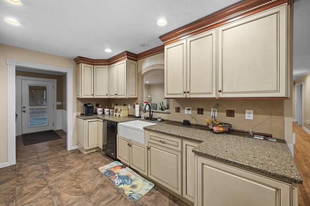 kitchen featuring cream cabinetry, dishwasher, and a sink