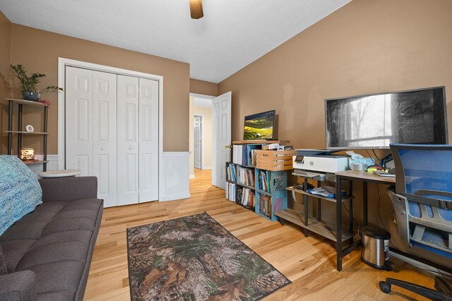 living area featuring a wainscoted wall, a ceiling fan, and wood finished floors