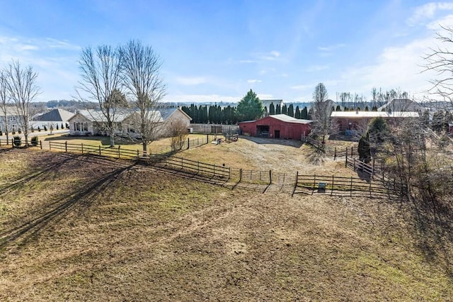 view of yard featuring an outbuilding, a rural view, and fence