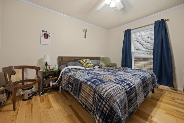 bedroom featuring ornamental molding, ceiling fan, and light wood-style flooring