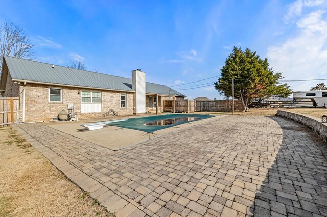 view of swimming pool featuring a diving board, a patio area, a fenced backyard, and a fenced in pool