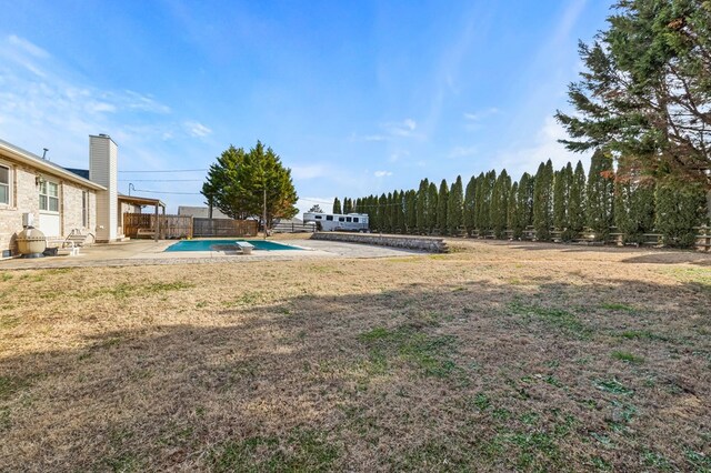 view of yard featuring a patio area, fence, and a fenced in pool