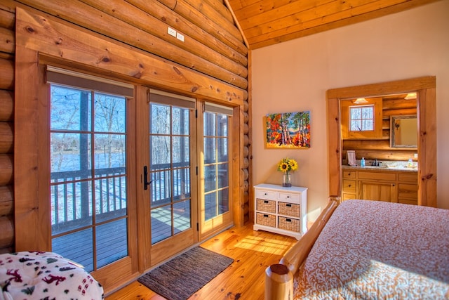 bedroom with access to exterior, lofted ceiling, rustic walls, and light wood finished floors