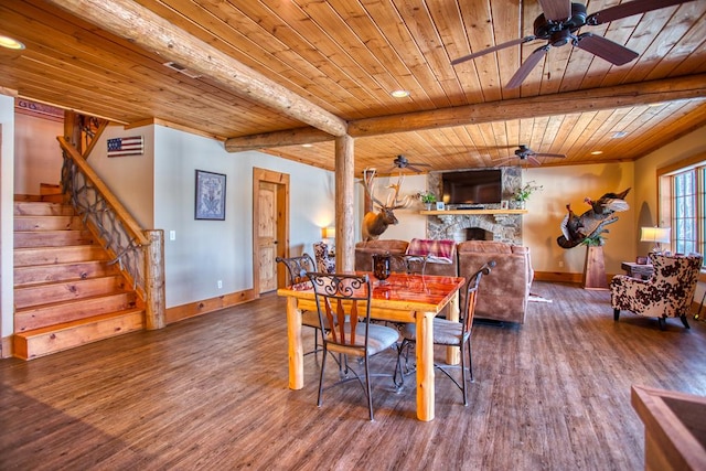 dining room featuring wooden ceiling, ceiling fan, wood finished floors, stairs, and a fireplace