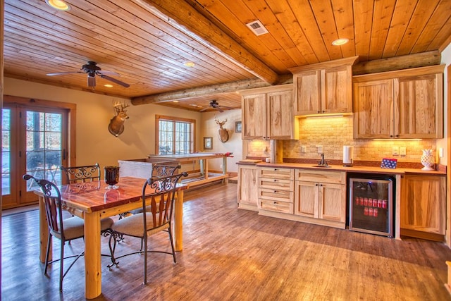 dining room featuring wine cooler, beam ceiling, visible vents, wood finished floors, and wooden ceiling