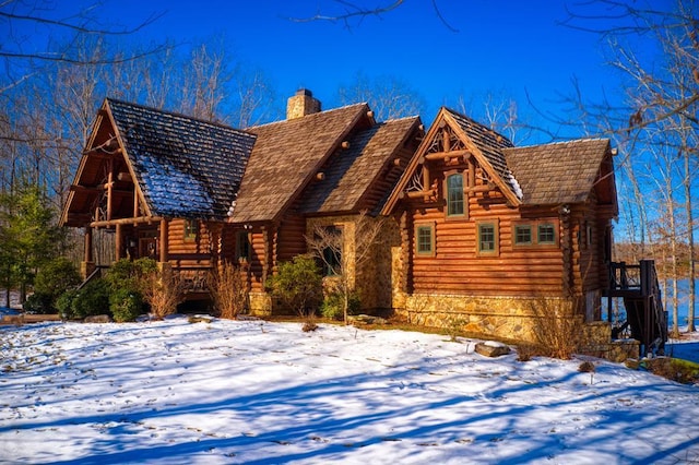 log-style house with a chimney and log siding