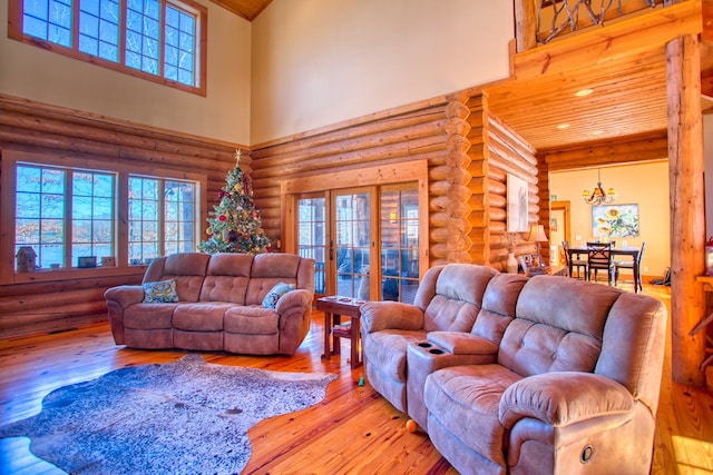 living area featuring a towering ceiling, wood-type flooring, wood ceiling, and log walls