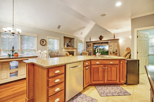 kitchen with dishwasher, open floor plan, a lit fireplace, pendant lighting, and a sink