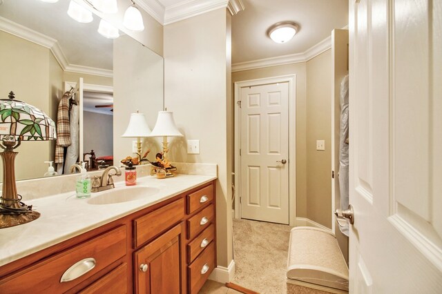 bathroom featuring baseboards, ornamental molding, and vanity