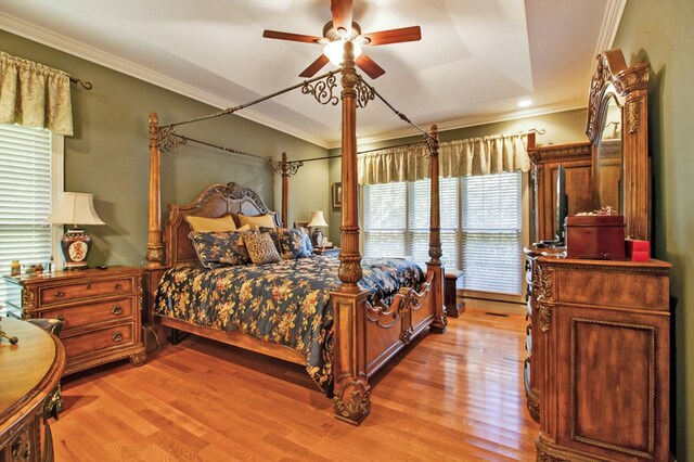 bedroom featuring crown molding, light wood finished floors, and ceiling fan