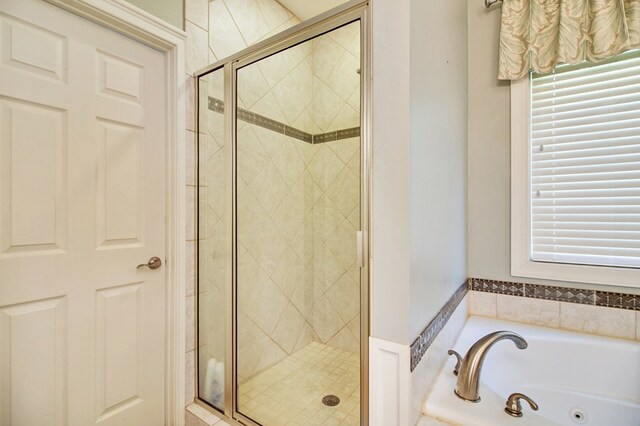 full bathroom with a whirlpool tub and a shower stall