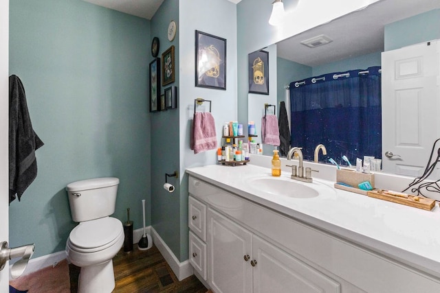 bathroom featuring toilet, wood finished floors, visible vents, vanity, and baseboards