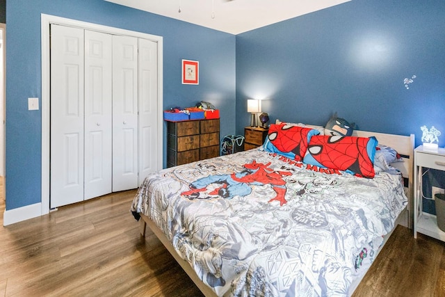 bedroom with a closet, wood finished floors, and baseboards