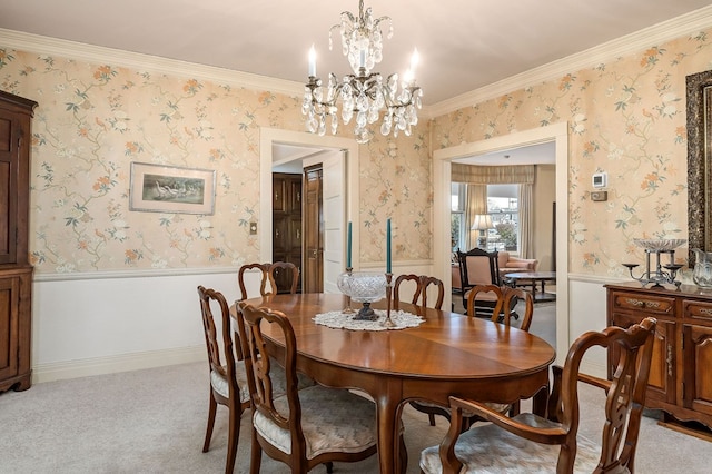 dining space featuring a wainscoted wall, an inviting chandelier, and wallpapered walls