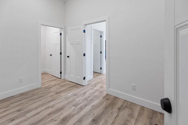 empty room with light wood-style flooring and baseboards