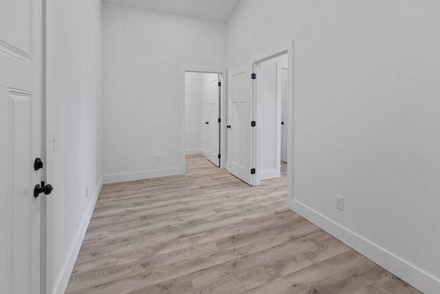 unfurnished room with light wood-style flooring and baseboards