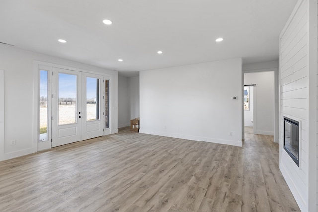 unfurnished living room featuring a fireplace, light wood-style flooring, and recessed lighting