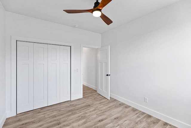 unfurnished bedroom with light wood-style floors, a ceiling fan, baseboards, and a closet