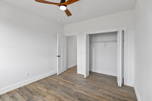 unfurnished bedroom featuring ceiling fan, a closet, baseboards, and dark wood-type flooring