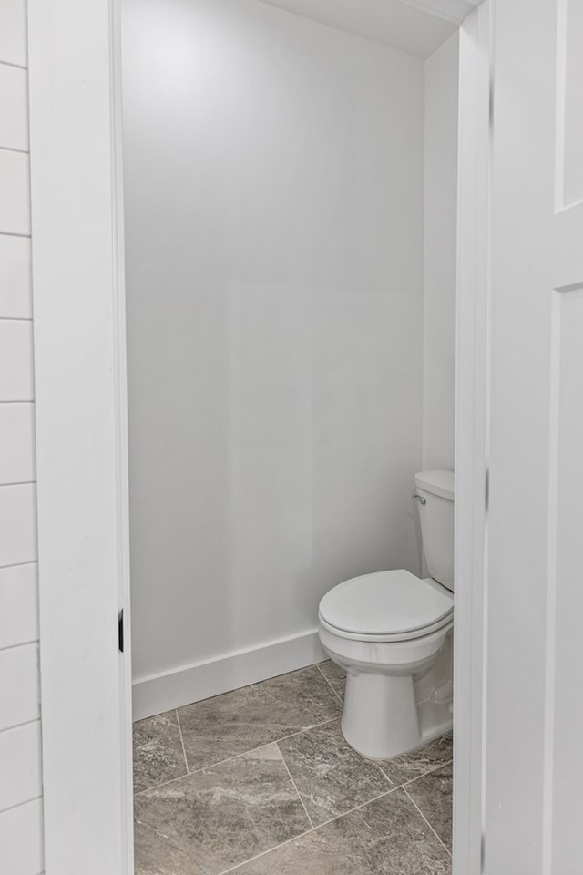 bathroom featuring toilet and baseboards