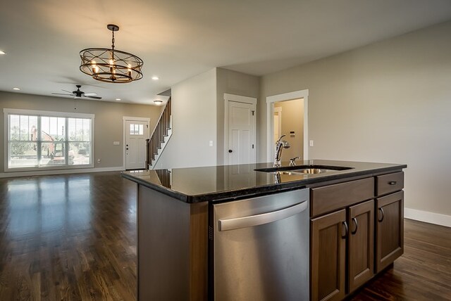 kitchen featuring decorative light fixtures, a sink, open floor plan, dishwasher, and a center island with sink