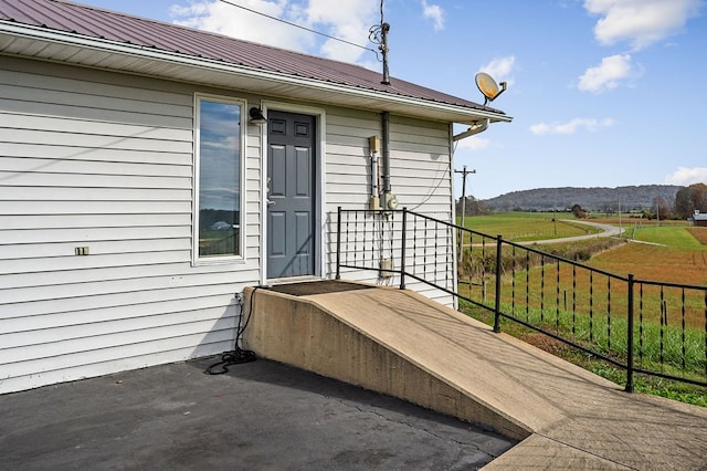 exterior space featuring metal roof, fence, and a mountain view