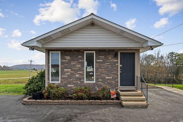 view of front of home featuring entry steps and stone siding