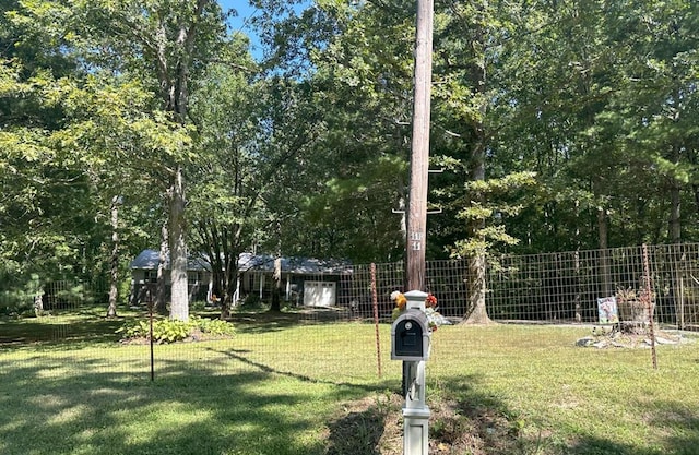 view of community featuring a lawn and fence