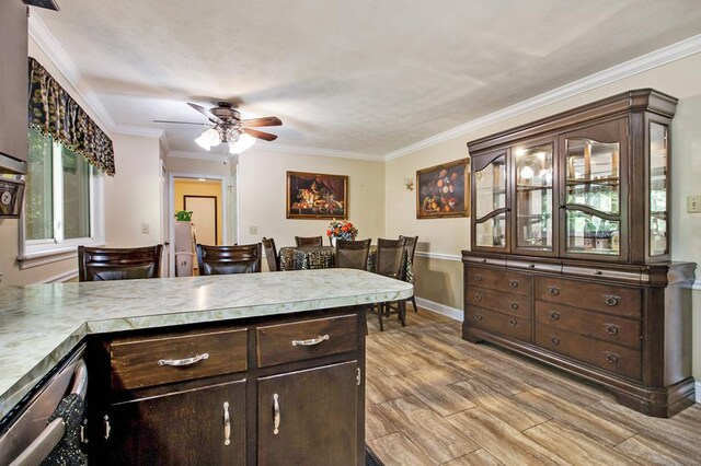 kitchen featuring light wood finished floors, baseboards, light countertops, crown molding, and dark brown cabinets